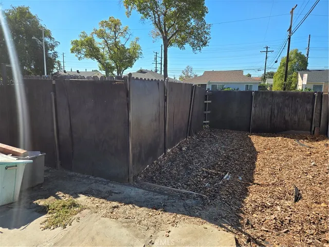 a view of a yard with plants and trees