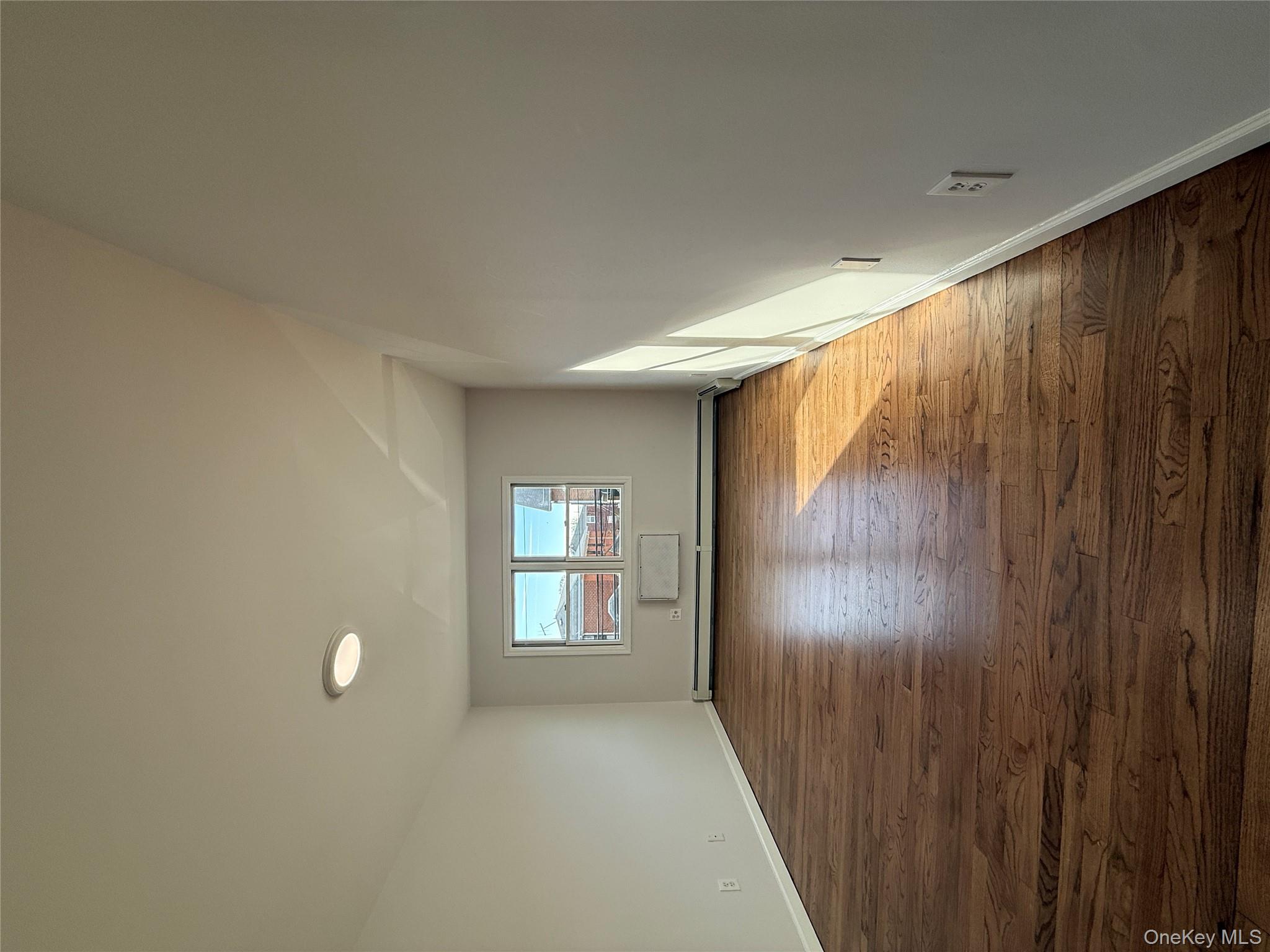 130-09 58th Road Queens, NY 11355 - Photo 14 of 18 Unfurnished room featuring dark wood-type flooring and a baseboard heating unit