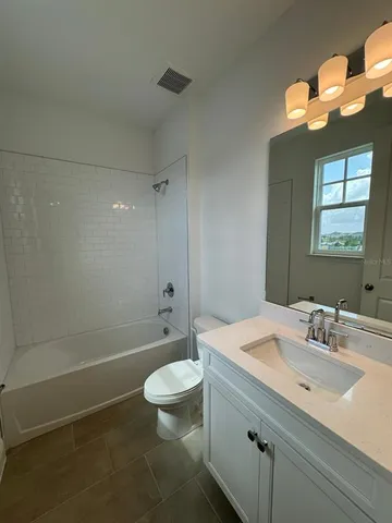 a bathroom with a granite countertop sink mirror and window