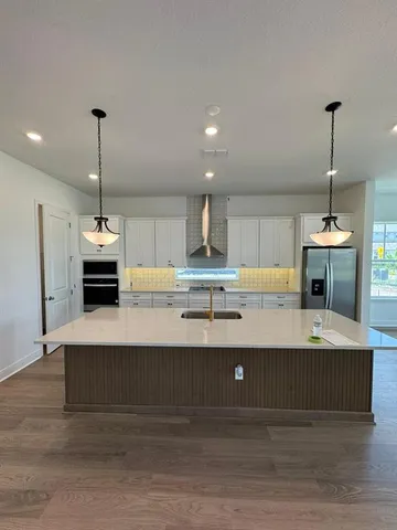 a kitchen with kitchen island a sink stainless steel appliances and cabinets