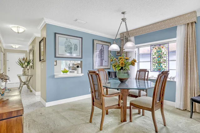 a dining room with furniture a large window and a chandelier
