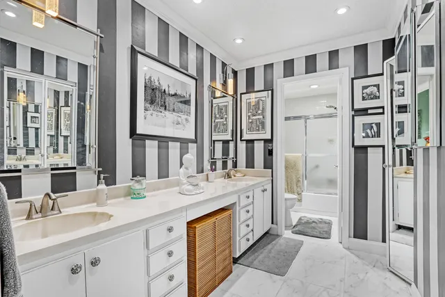 a spacious bathroom with double vanity sinks a large mirror and a shower