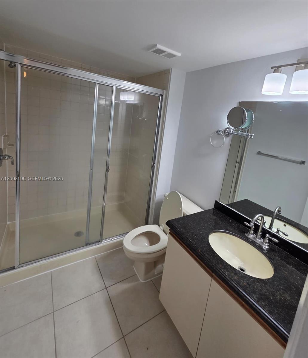 8871 Wiles Road, Unit 208 Coral Springs, FL 33067 - Photo 11 of 15 a bathroom with a granite countertop sink toilet and shower