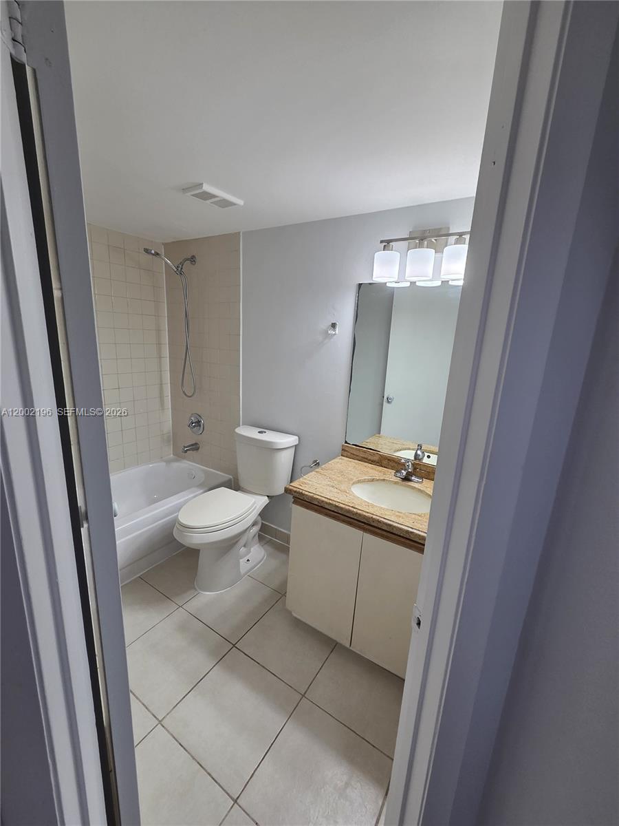 8871 Wiles Road, Unit 208 Coral Springs, FL 33067 - Photo 12 of 15 a bathroom with a granite countertop sink mirror vanity and toilet