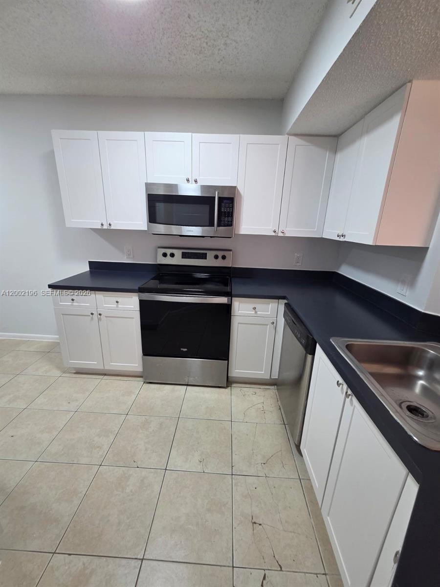 8871 Wiles Road, Unit 208 Coral Springs, FL 33067 - Photo 2 of 15 a kitchen with stainless steel appliances granite countertop a sink and a stove