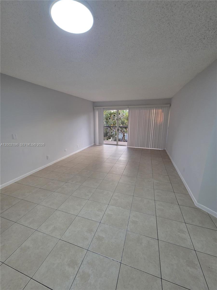 8871 Wiles Road, Unit 208 Coral Springs, FL 33067 - Photo 9 of 15 a view of an empty room with windows