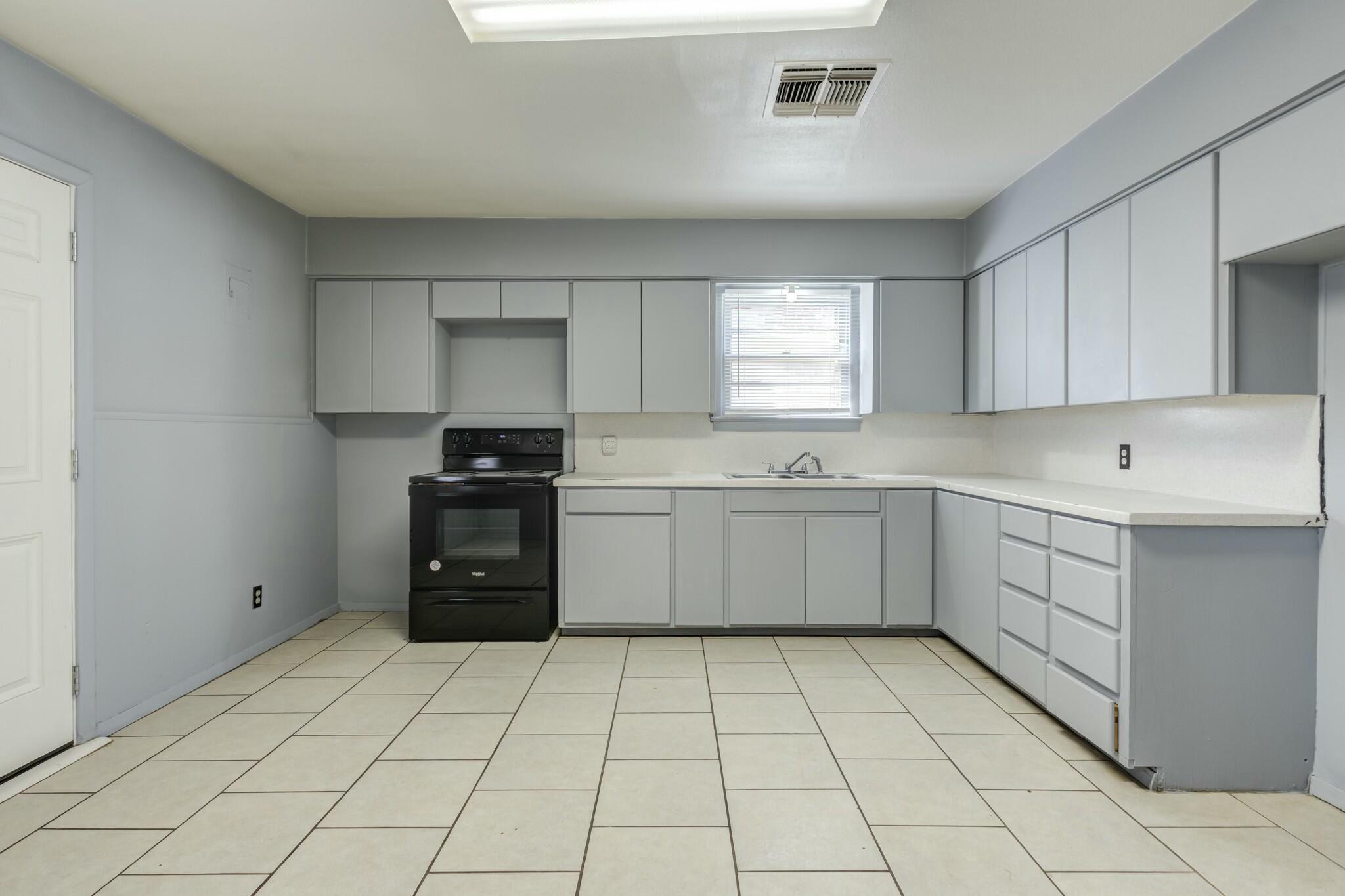 3013 45th Street Lubbock, TX 79413 - Photo 11 of 30 a kitchen with a cabinets and appliances