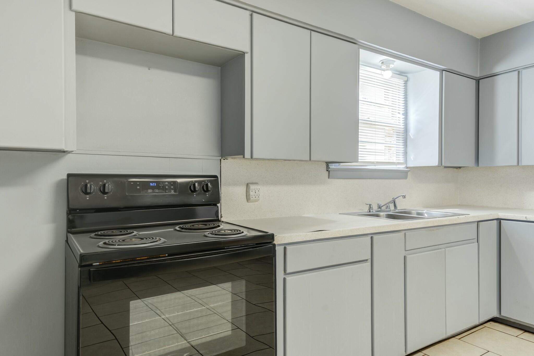 3013 45th Street Lubbock, TX 79413 - Photo 16 of 30 a kitchen with appliances a sink and a window