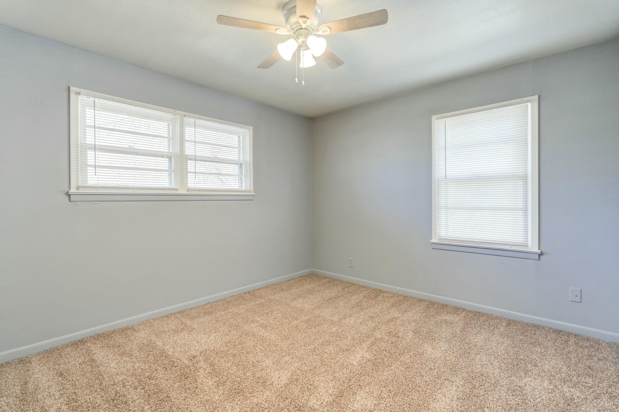 3013 45th Street Lubbock, TX 79413 - Photo 23 of 30 an empty room with a window and a fan