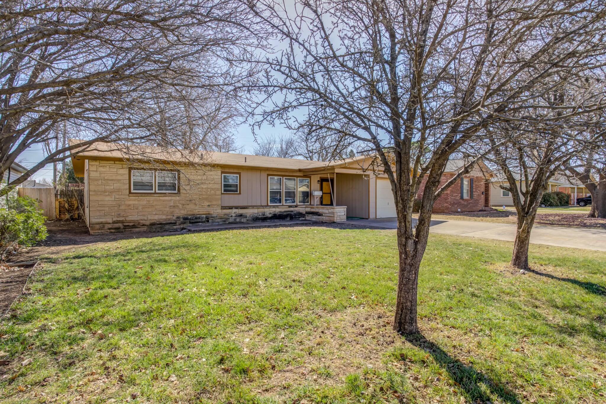 3013 45th Street Lubbock, TX 79413 - Photo 3 of 30 a front view of house with yard and trees in the background