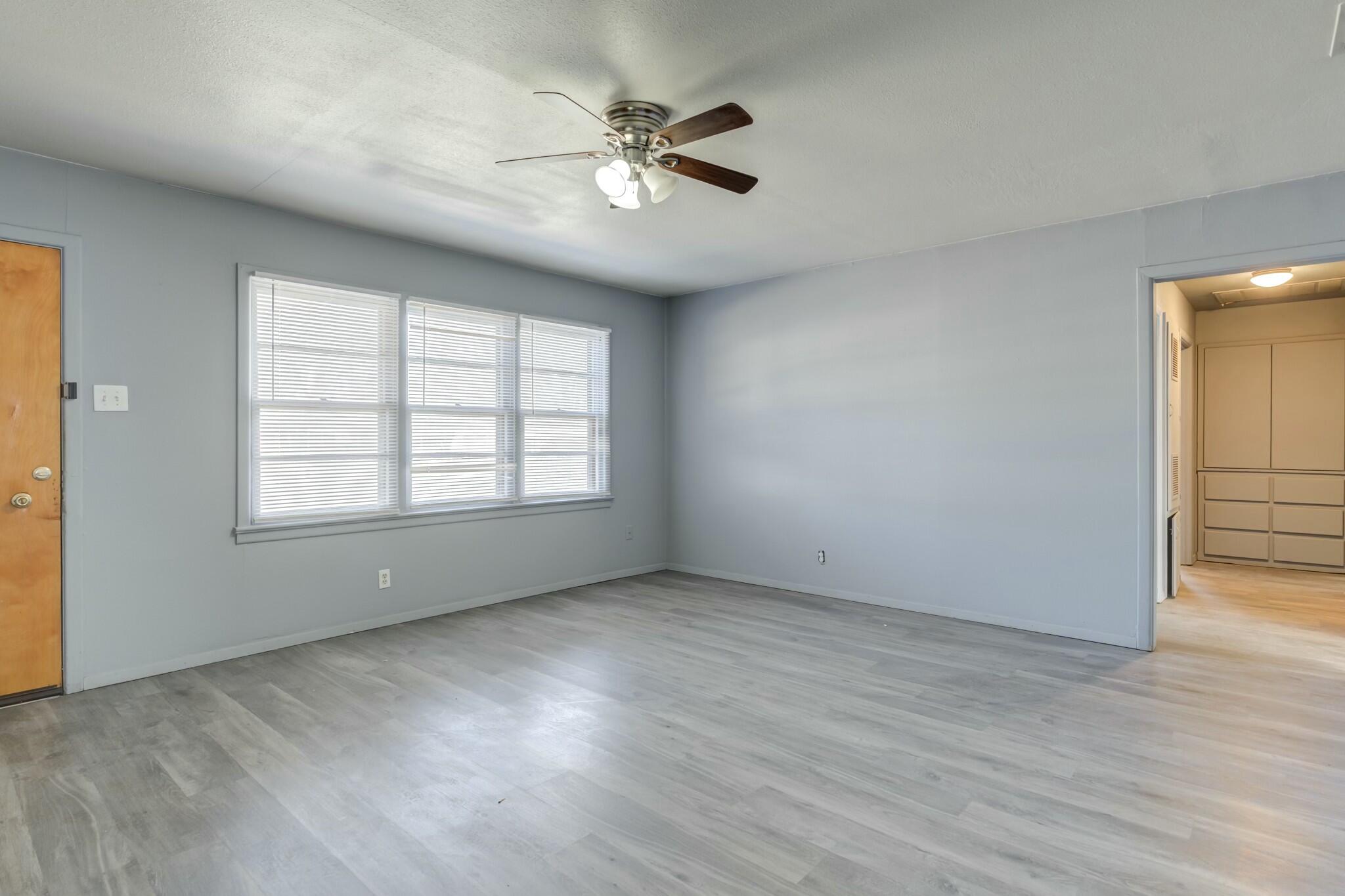 3013 45th Street Lubbock, TX 79413 - Photo 6 of 30 wooden floor in an empty room with a window