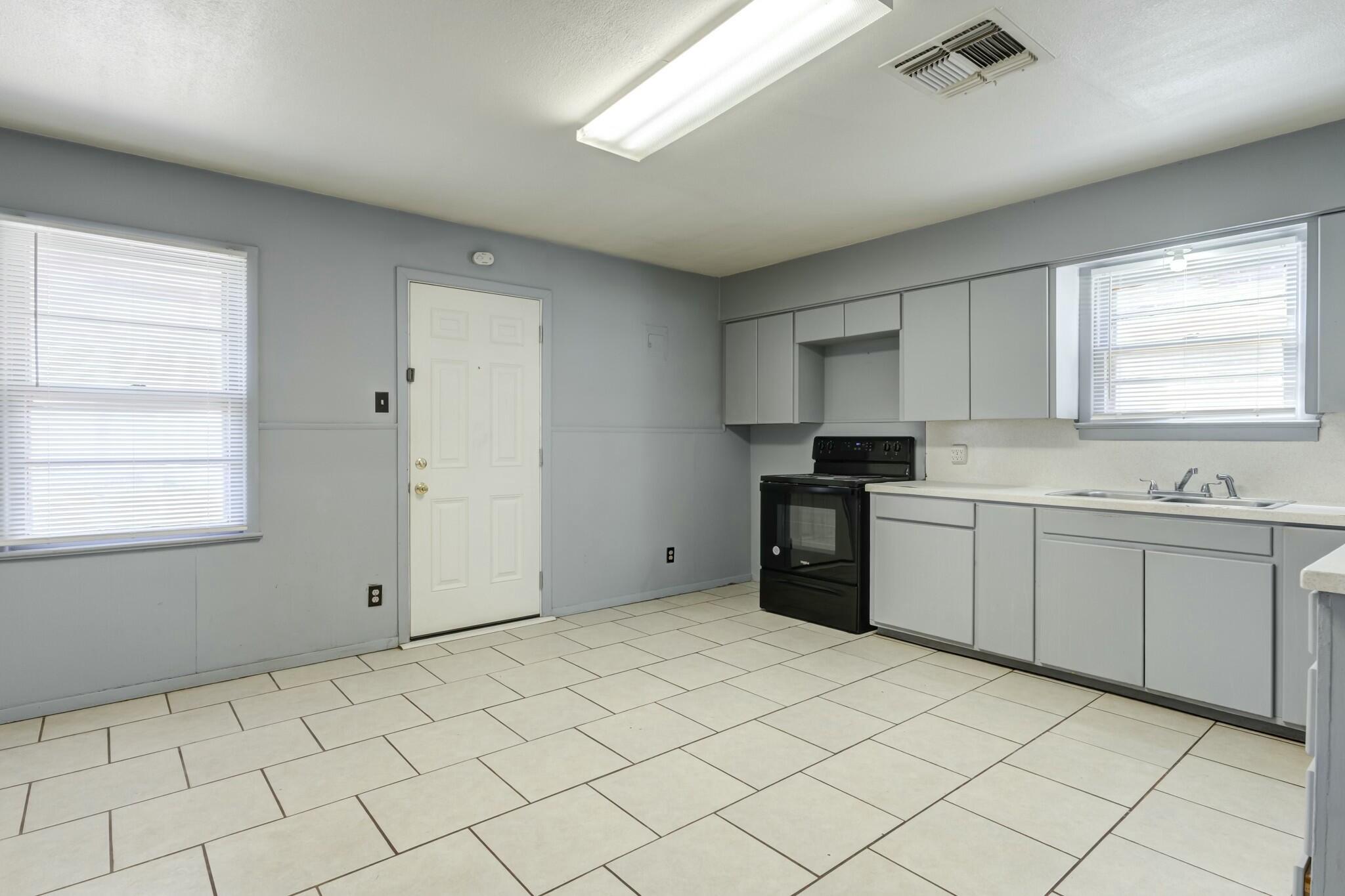 3013 45th Street Lubbock, TX 79413 - Photo 10 of 30 a kitchen with a sink cabinets and window