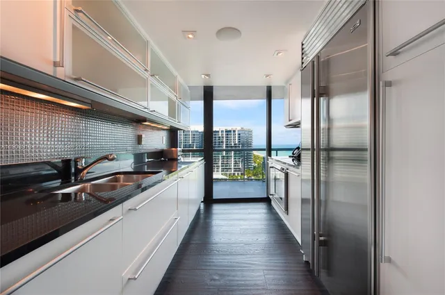 a kitchen with stainless steel appliances granite countertop a sink a stove and a refrigerator