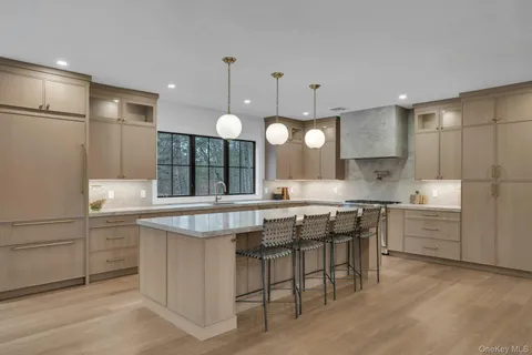 a kitchen with kitchen island granite countertop a sink and refrigerator