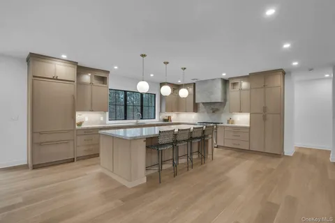 a kitchen with stainless steel appliances granite countertop a sink a stove and a wooden floors