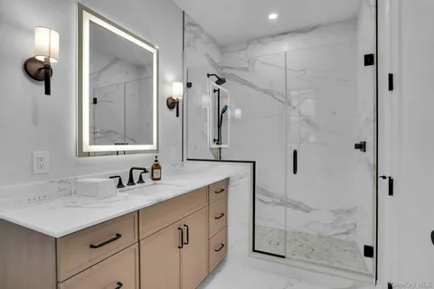 a bathroom with a shower sink and mirror