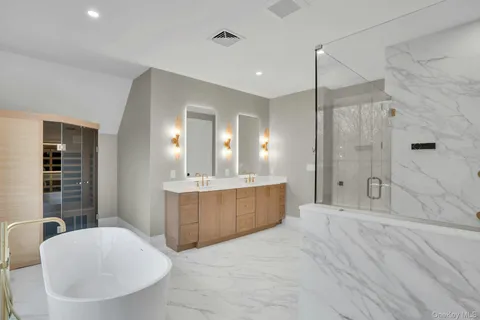 a bathroom with a tub shower sink and mirror