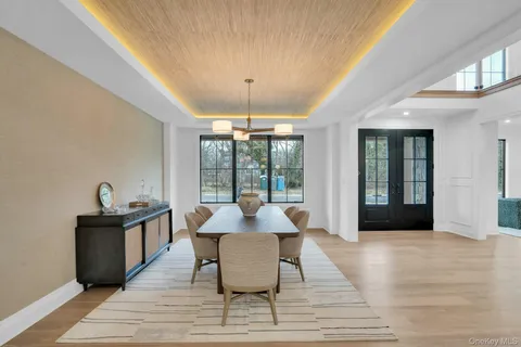 a dining room with wooden floor a chandelier a wooden table and chairs