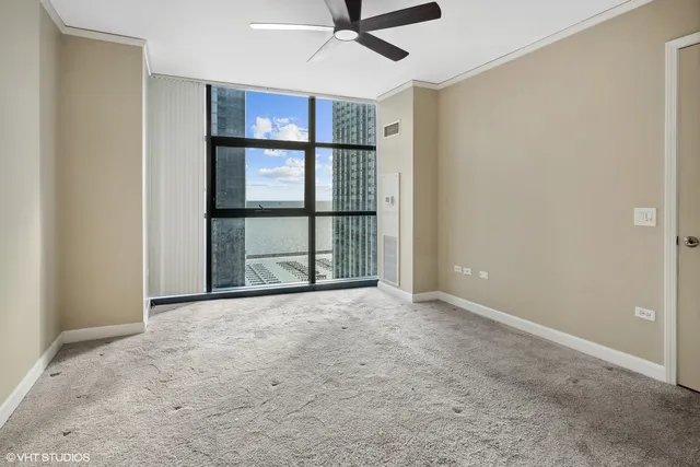 an empty room with ceiling fan and window