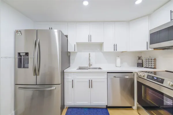 a kitchen with stainless steel appliances a refrigerator sink and microwave