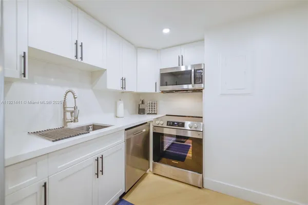 a kitchen with stainless steel appliances granite countertop a sink stove and microwave