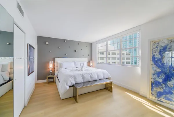 a spacious bedroom with a bed and a window