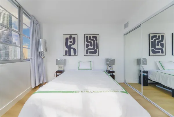 a spacious bedroom with a bed and painting on the wall
