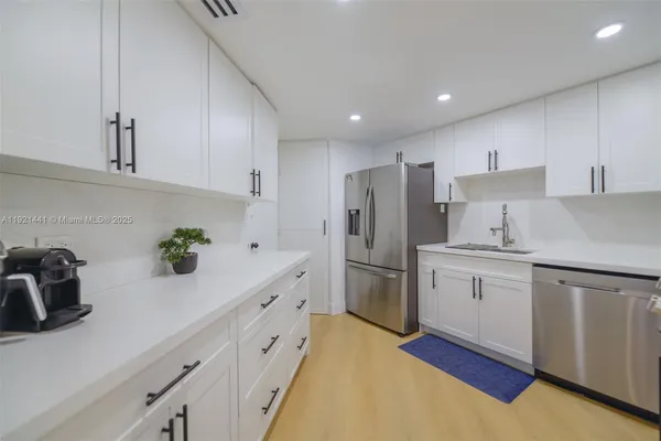 a kitchen with white cabinets and stainless steel appliances