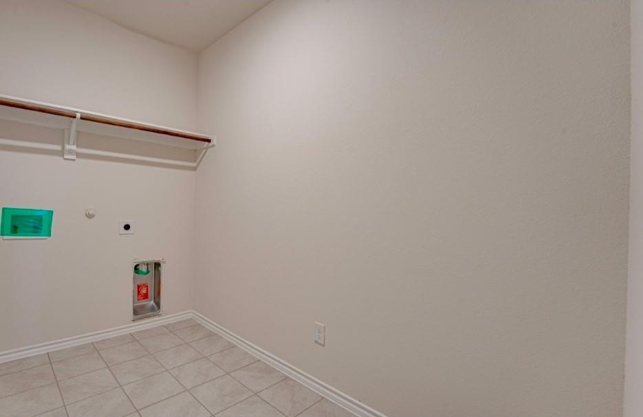 1614 Potomac Lane Blue Ridge, TX 75424 - Photo 10 of 18 Utility area featuring neutral tile flooring, a wall-mounted shelving unit, and appliance hookups