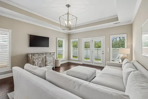 a living room with furniture a flat screen tv and a large window