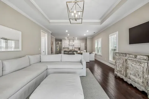 a living room with furniture a flat screen tv and kitchen view
