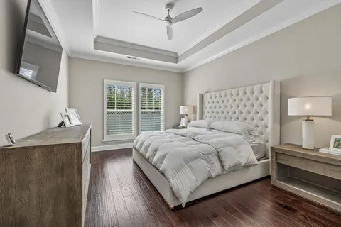a bedroom with a large bed and a flat tv screen on dresser