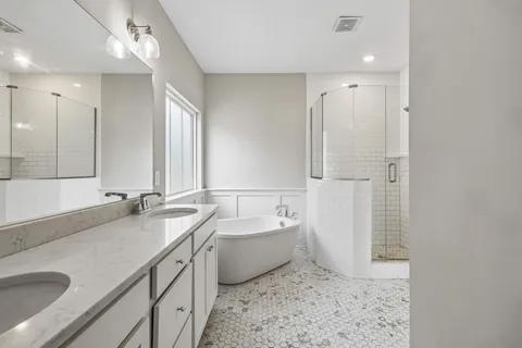a bathroom with a tub sink and mirror