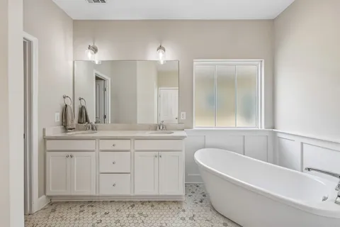 a bathroom with a granite countertop bathtub sink and mirror