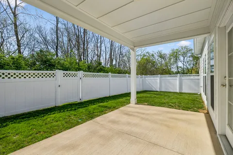 a view of a backyard with plants and wooden fence