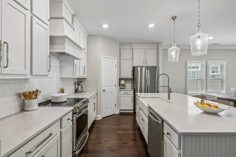 a kitchen with stainless steel appliances a sink a stove a refrigerator and cabinets