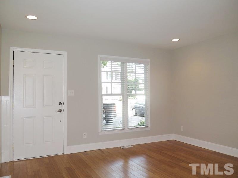 2544 Noble Road Raleigh, NC 27608 - Photo 3 of 11 an empty room with wooden floor and windows