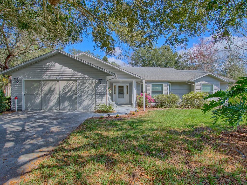 11034 Riverside Road Leesburg, FL 34788 - Photo 1 of 1 FRONT VIEW W/LONG DRIVEWAY AND SCREENED GARAGE DOOR