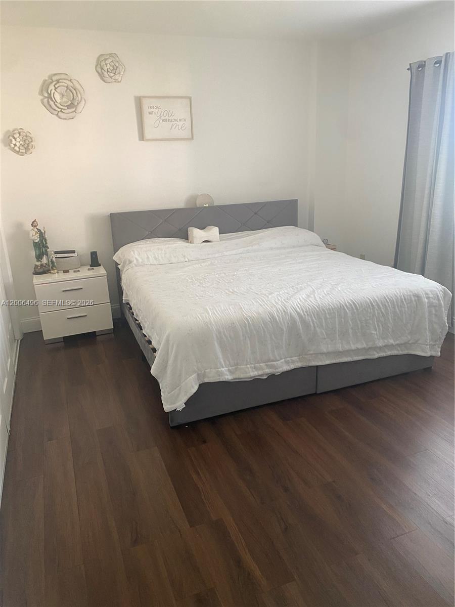 900 Southwest 84th Avenue, Unit 415D Miami, FL 33144 - Photo 16 of 19 a bedroom with a bed wooden floor and a table