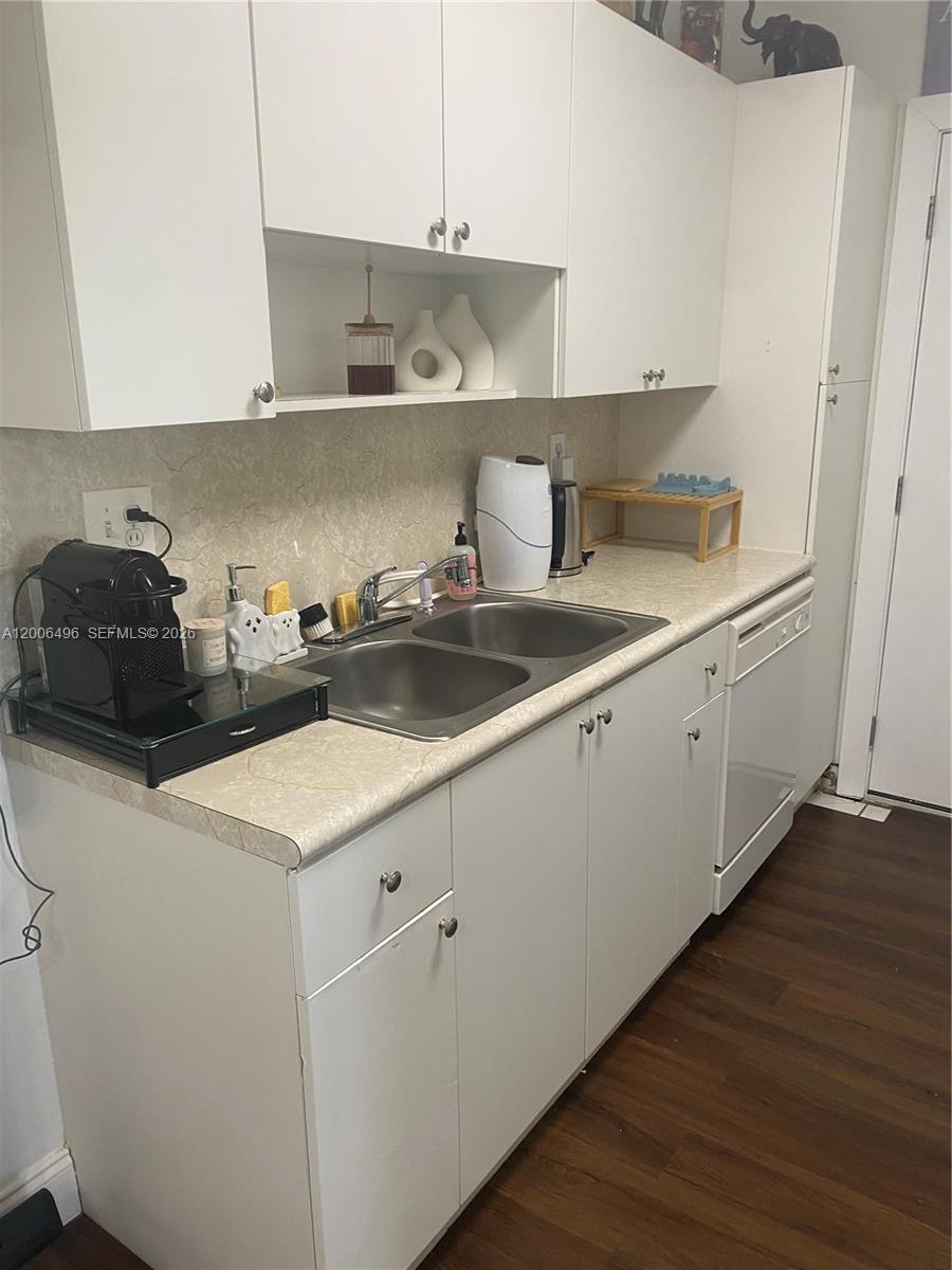 900 Southwest 84th Avenue, Unit 415D Miami, FL 33144 - Photo 5 of 19 a kitchen with a sink a stove and cabinets