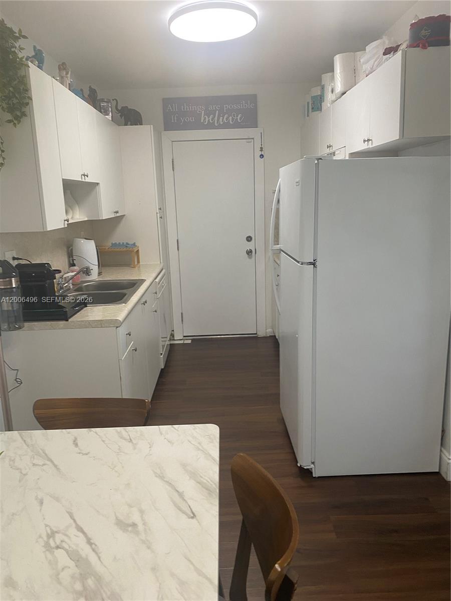 900 Southwest 84th Avenue, Unit 415D Miami, FL 33144 - Photo 6 of 19 a kitchen with a sink and wooden floor