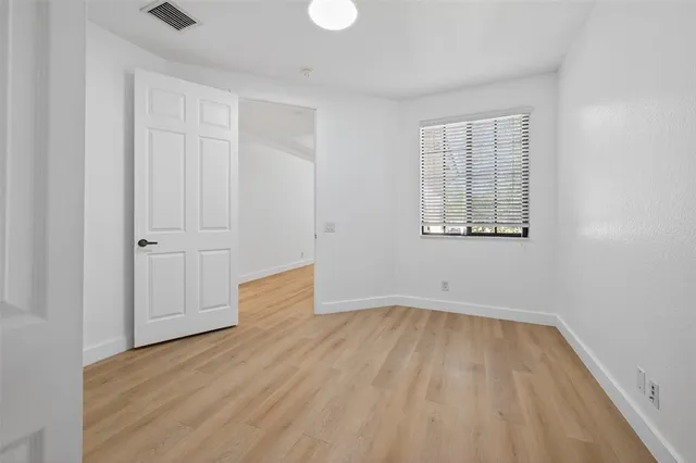 an empty room with wooden floor and closet
