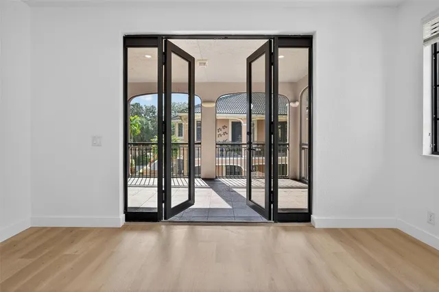 a balcony view with large trees and wooden fence