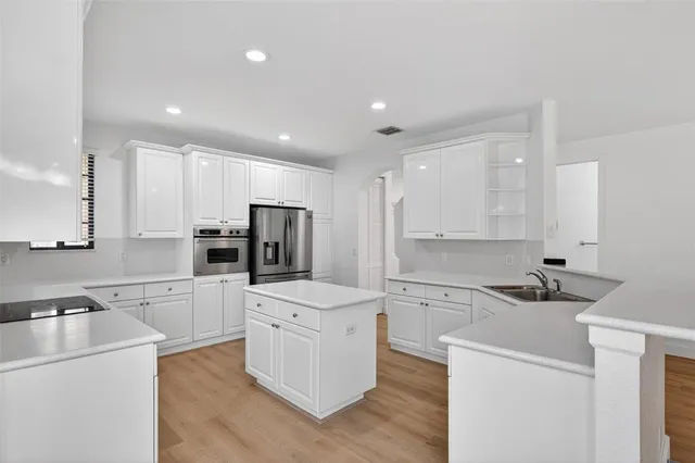 a kitchen with white cabinets and stainless steel appliances