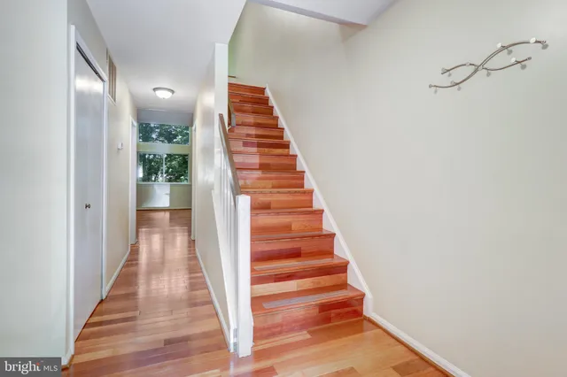 an empty room with windows fireplace and wooden floor