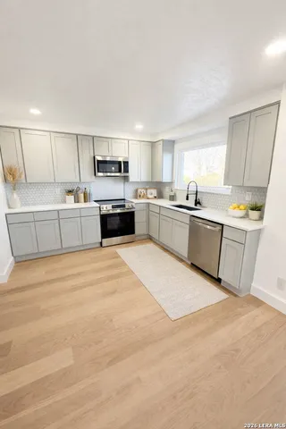 a large kitchen with cabinets and stainless steel appliances