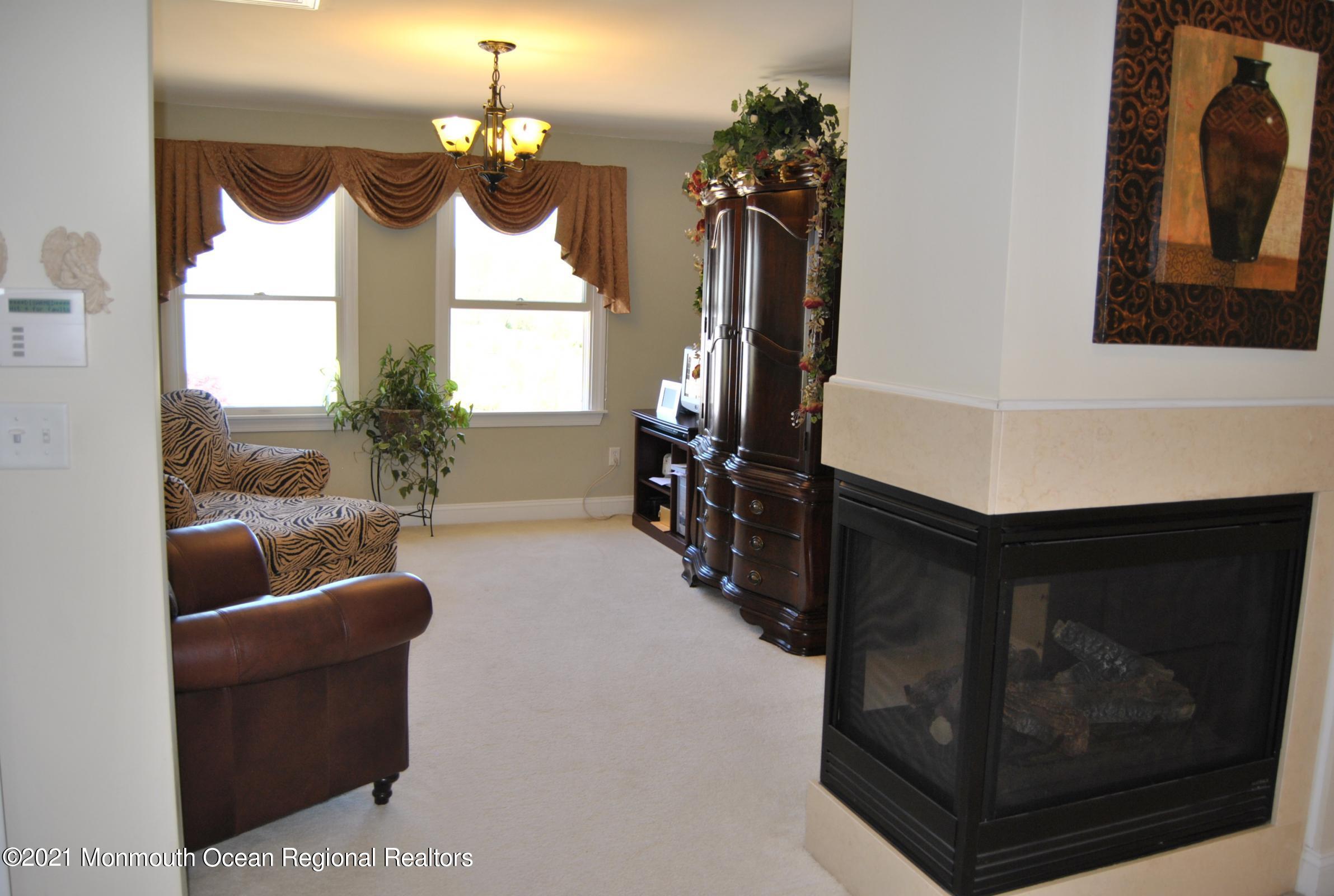2 Hanging Rock Road Freehold, NJ 07728 - Photo 29 of 55 a living room with furniture a chandelier and a fireplace