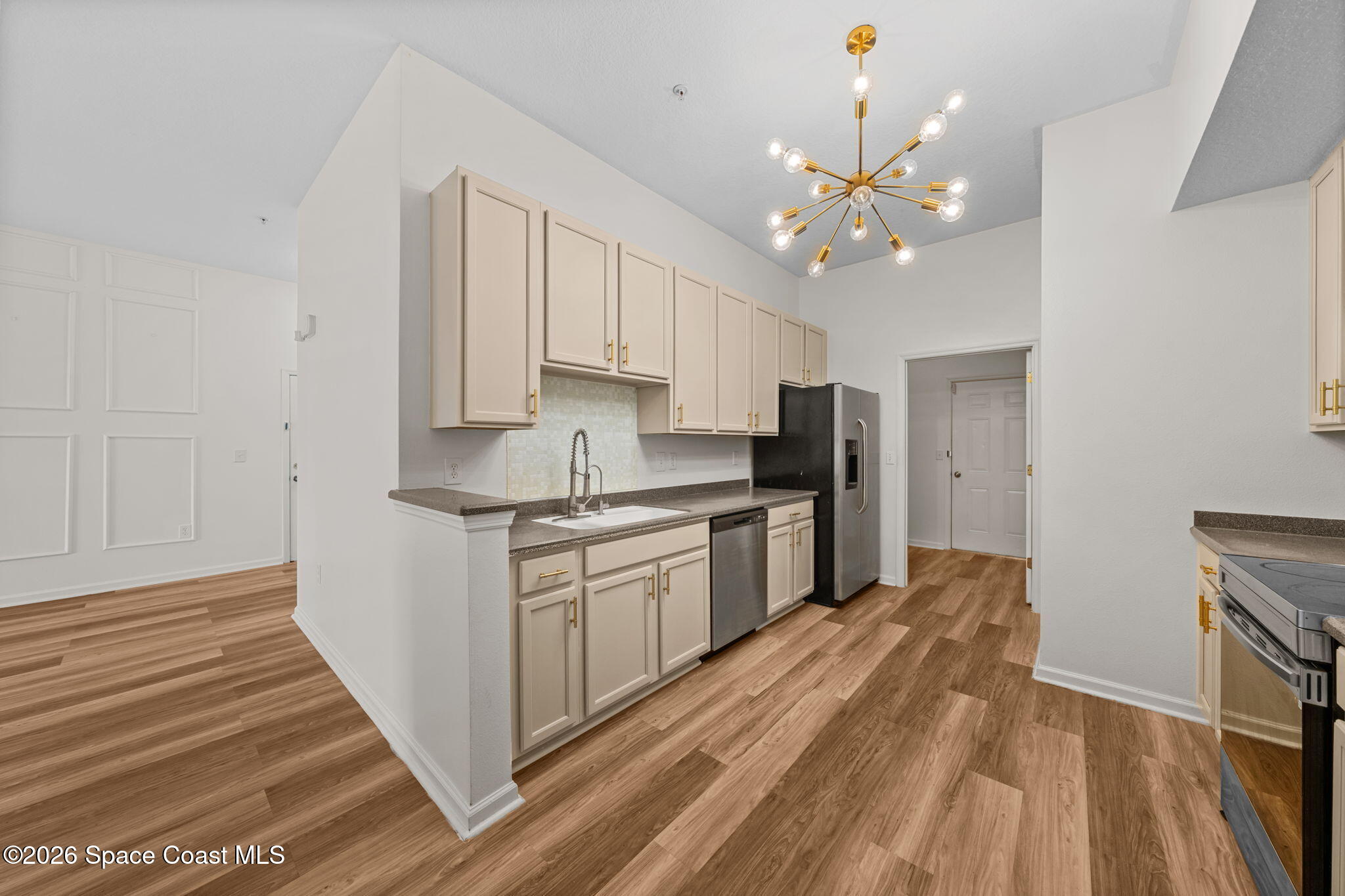 4056 Meander Place, Unit 104 Rockledge, FL 32955 - Photo 3 of 25 a kitchen with kitchen island granite countertop a sink cabinets and stainless steel appliances