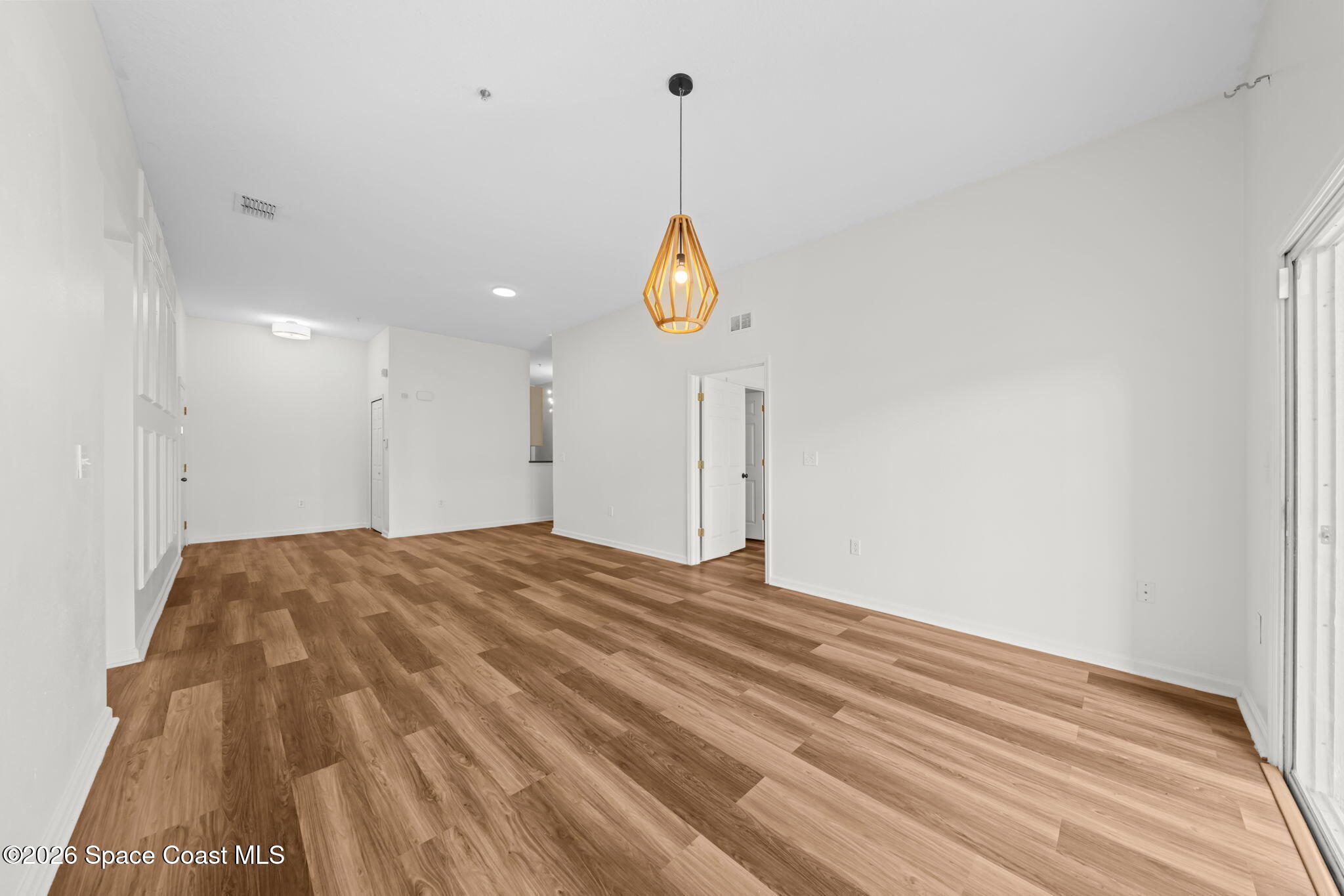 4056 Meander Place, Unit 104 Rockledge, FL 32955 - Photo 6 of 25 a view of a room with wooden floor and white walls