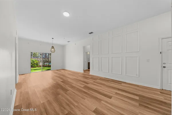 a view of a room with wooden floor and a window